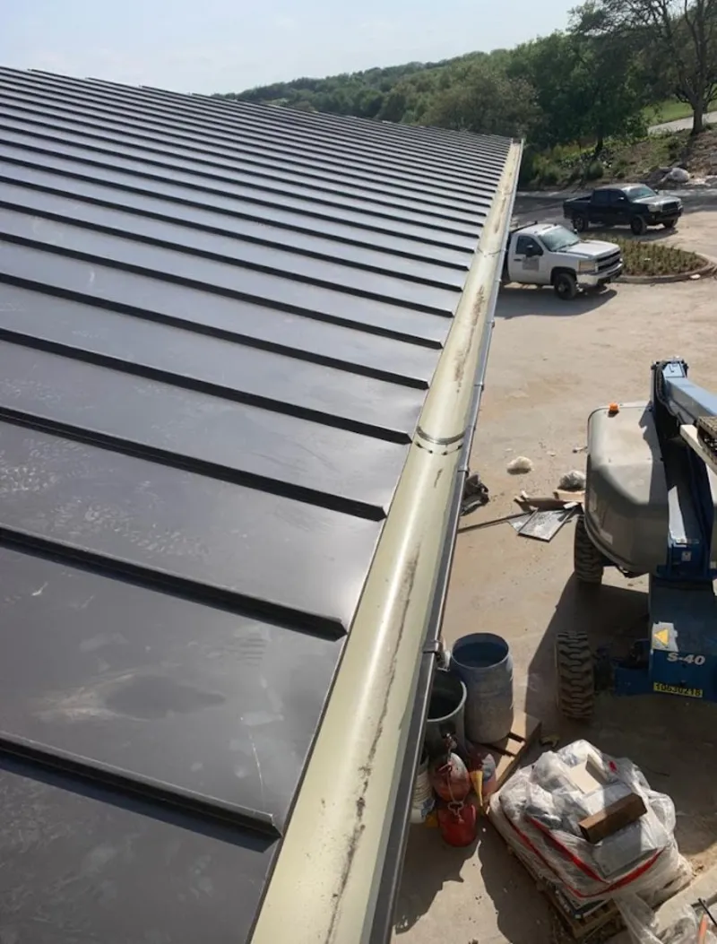 Standing seam panel and gutter detail on a metal roofing jobsite in Long Branch